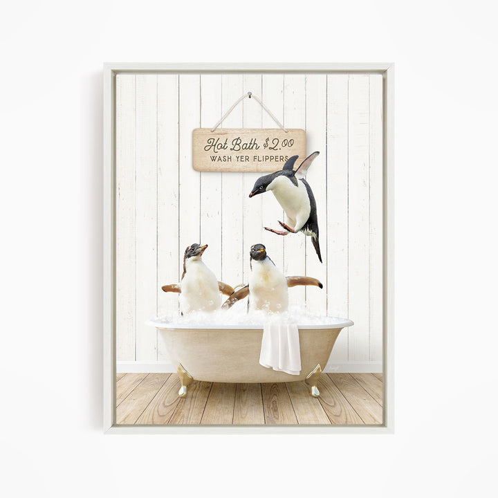 A framed image depicting three penguins sitting in a bathtub, with one penguin flying above the tub and another penguin sitting on the edge of the tub.