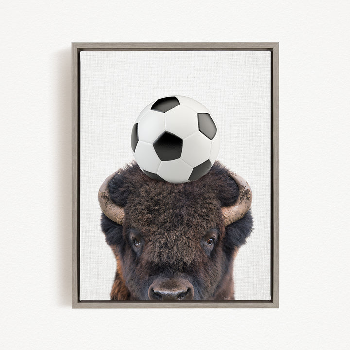 A buffalo with a soccer ball on its head.