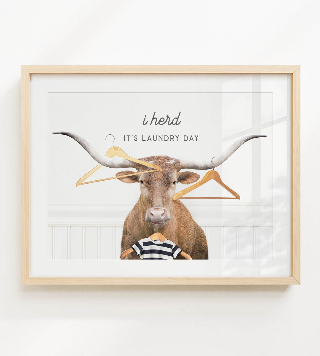 a bull with large horns, surrounded by various clothes hangers, with the text "It's laundry day" written above the bull.