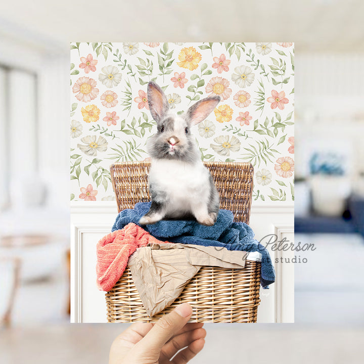 a rabbit sitting on top of clothes in a basket