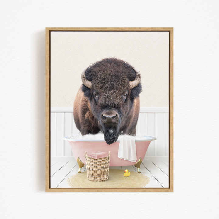 A buffalo with a long beard is sitting in a pink bathtub filled with water, surrounded by a basket of toys and a yellow rubber duck.