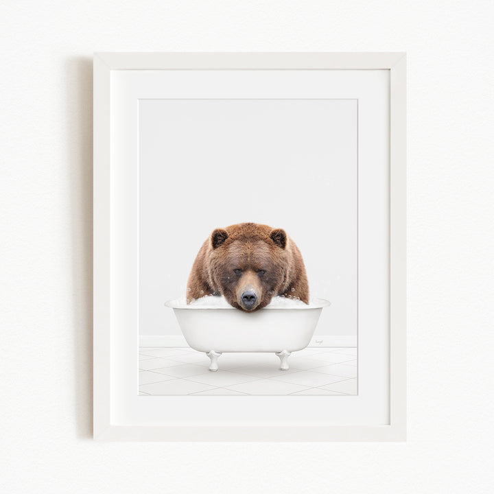 A brown bear is sitting in a white bathtub, appearing to be enjoying a relaxing bath.