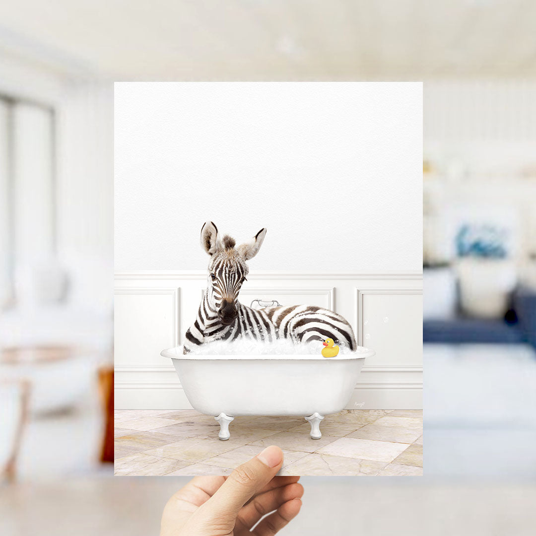 A zebra is sitting in a white bathtub filled with water, surrounded by a yellow rubber duck.
