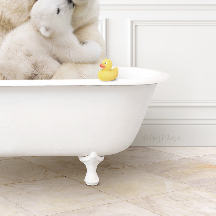 A white claw-foot bathtub filled with water, with a small yellow rubber duck floating on the surface.