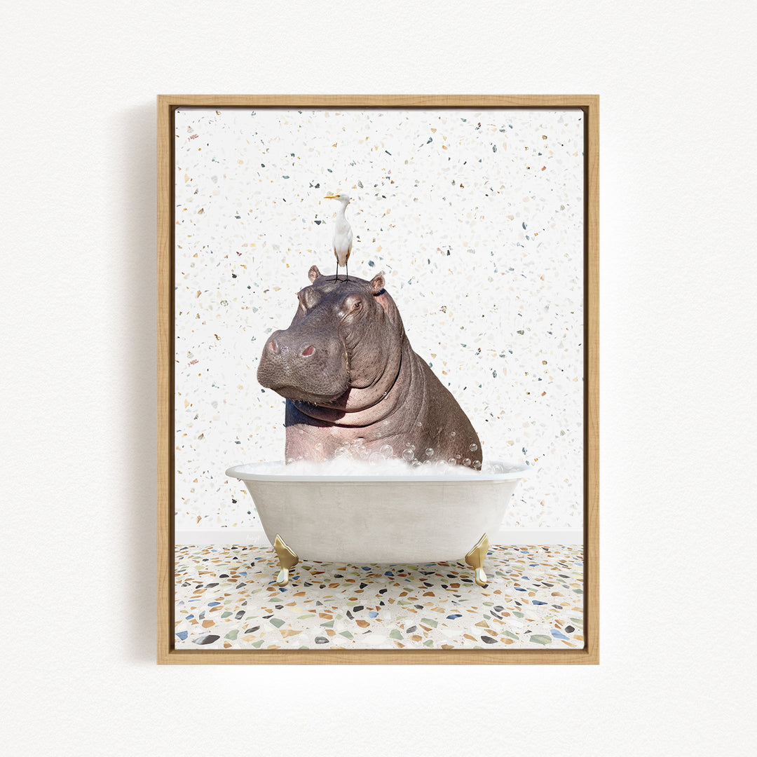 A framed image depicting a hippopotamus sitting in a bathtub, with a bird perched on its head.