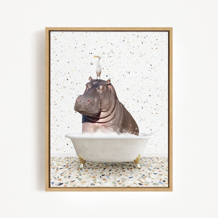 A framed image depicting a hippopotamus sitting in a bathtub, with a bird perched on its head.