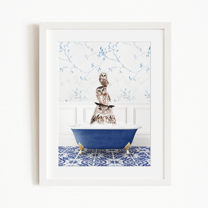 A framed image depicting three owls sitting in a blue bathtub, with a patterned tile floor and a floral wallpaper in the background.