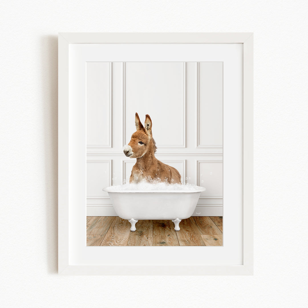 A donkey is sitting in a white bathtub filled with bubbles, creating a playful and whimsical scene.