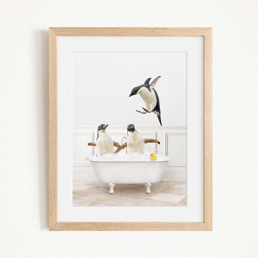 A framed image depicting three penguins sitting in a bathtub, with one penguin flying towards the tub.