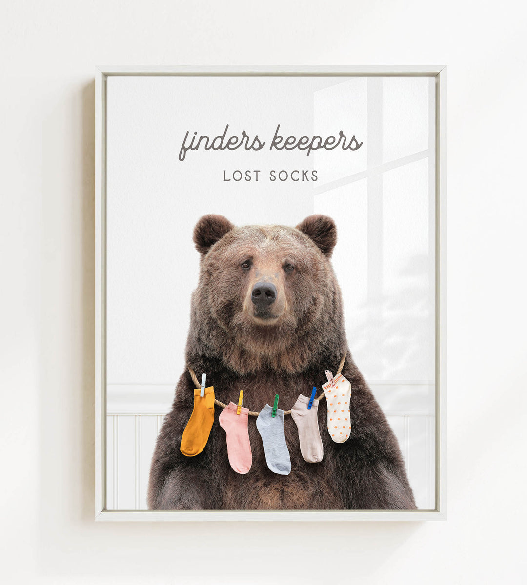 A large brown bear wearing a variety of colorful socks hanging from a clothesline.