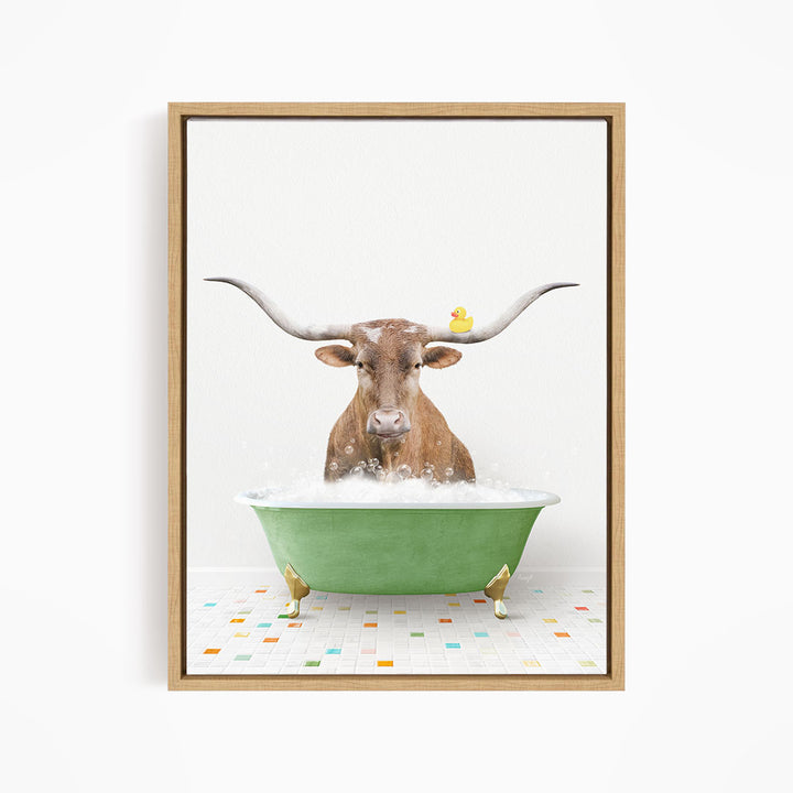 A brown cow with large horns is sitting in a green bathtub filled with bubbles, with a yellow rubber duck perched on its head.