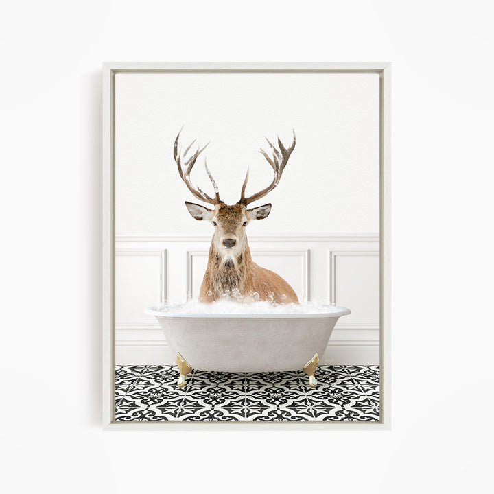 A deer with large antlers is sitting in a white bathtub filled with bubbles, creating a whimsical and unexpected scene.