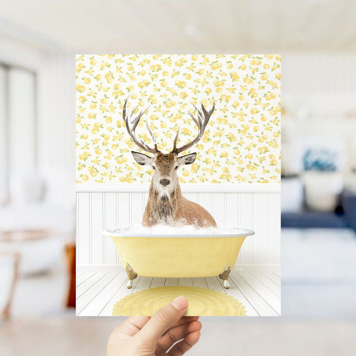A deer with antlers is sitting in a yellow bathtub filled with bubbles, surrounded by a yellow and white floral patterned wall.