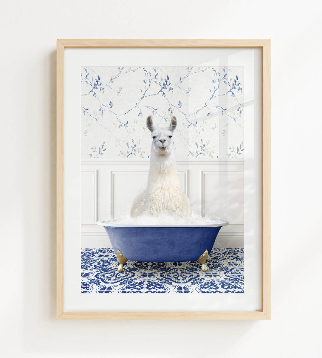 A white llama sitting in a blue bathtub filled with bubbles, surrounded by a blue and white patterned tile floor.