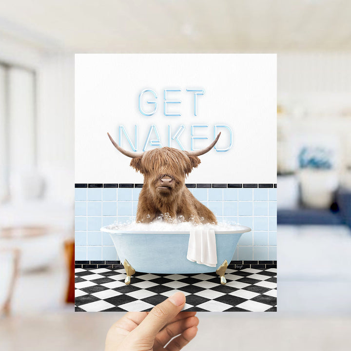 A hand holding a printed image of a brown cow sitting in a bathtub with the text "GET NAKED" displayed above it.