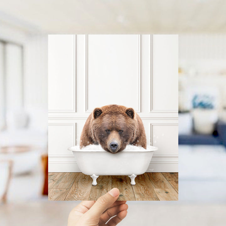 A brown bear is sitting in a white bathtub, appearing to be enjoying a relaxing bath.