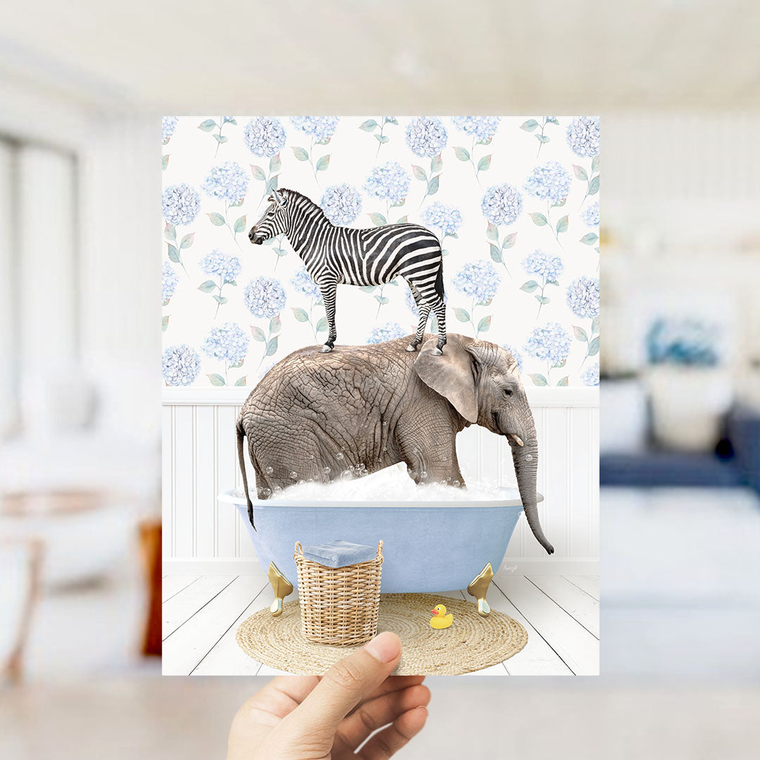 A hand holds up a collage of two images: a zebra standing on an elephant's back in a bathtub, and a yellow rubber duck floating in the water.