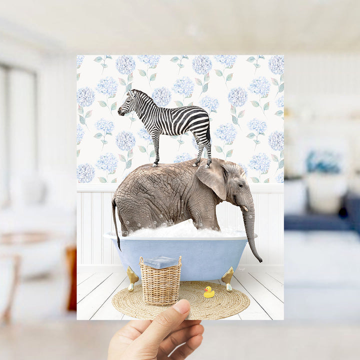 A hand holds up a collage of two images: a zebra standing on an elephant's back in a bathtub, and a yellow rubber duck floating in the water.