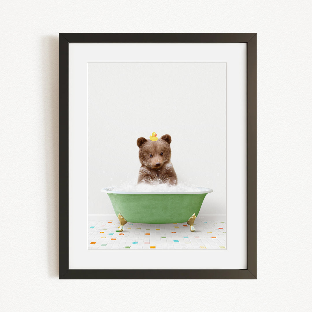A brown bear sitting in a green bathtub filled with bubbles, with a yellow rubber duck floating on the water.