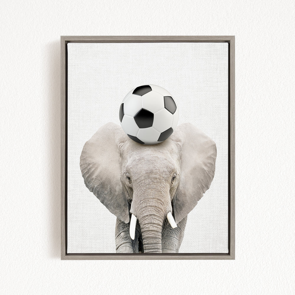 A gray elephant with a soccer ball on its head, standing against a white background.