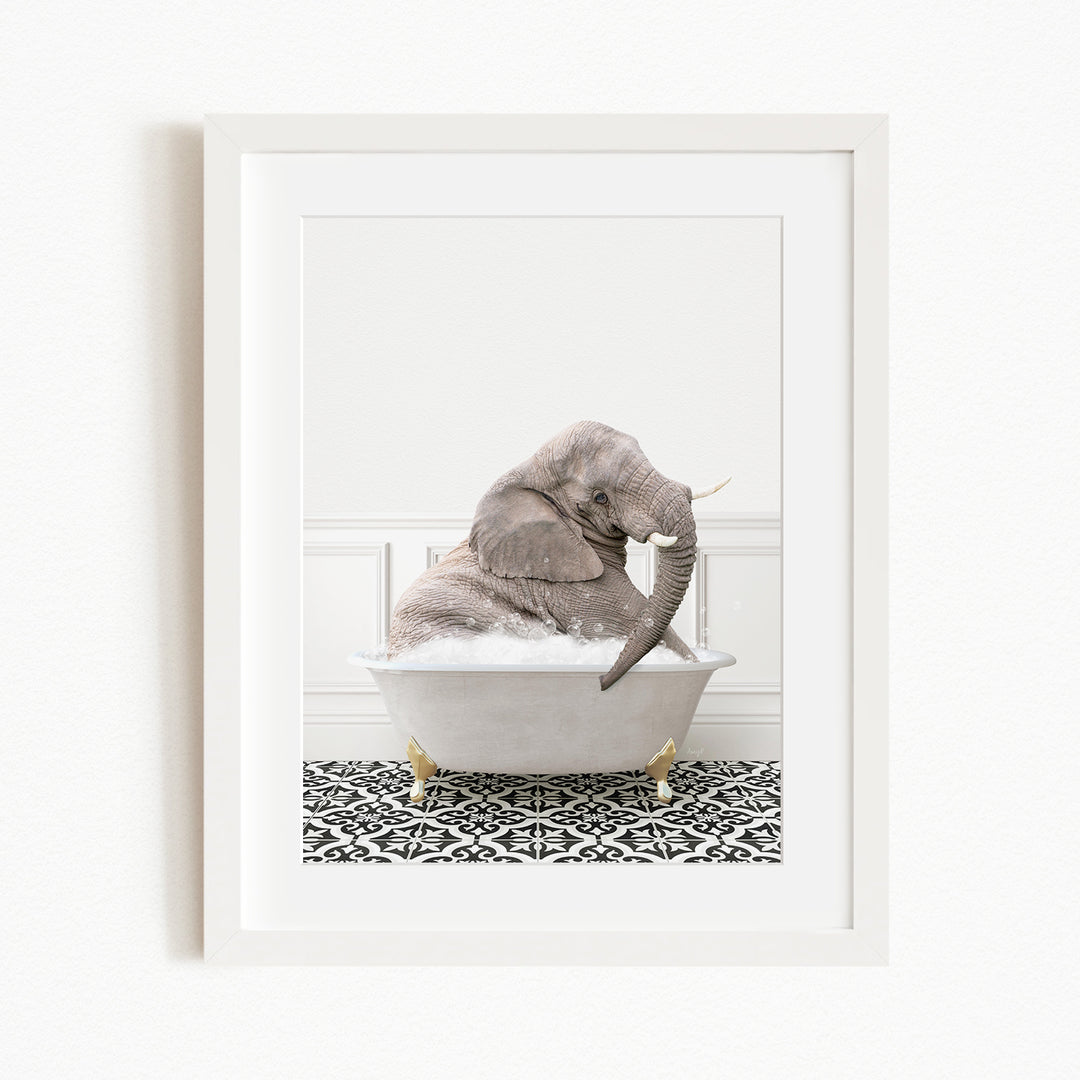 A gray elephant sitting in a white bathtub filled with water, surrounded by a black and white patterned rug.