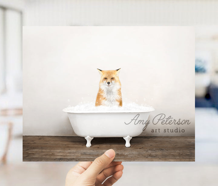 a person holding up a card with a picture of a fox in a bathtub