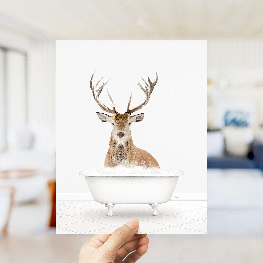 A deer with antlers is sitting in a bathtub filled with water, creating a whimsical and unexpected scene.