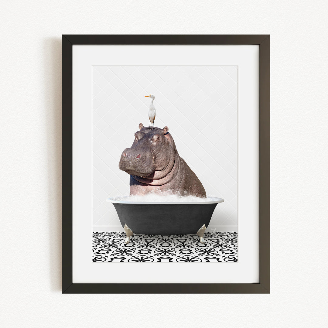 A framed image depicting a large hippopotamus sitting in a bathtub, with a white bird perched on its head.