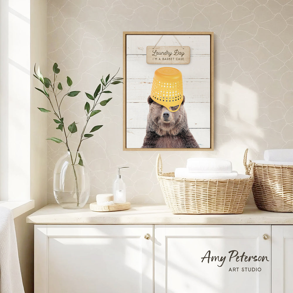 a framed picture of a bear wearing a yellow bucket hat, hanging on a wall above a white cabinet with baskets.