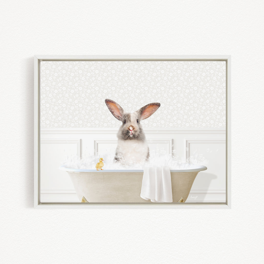 A fluffy white rabbit sits in a bathtub filled with bubbles, with a yellow rubber duck floating nearby.