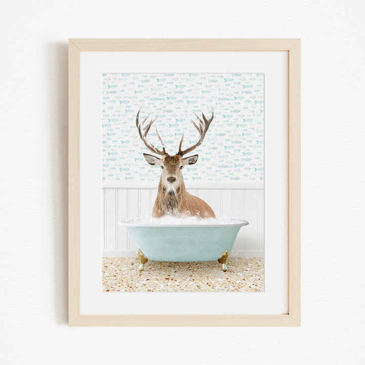 A deer with antlers is sitting in a light blue bathtub, surrounded by a patterned wall and a white floor.