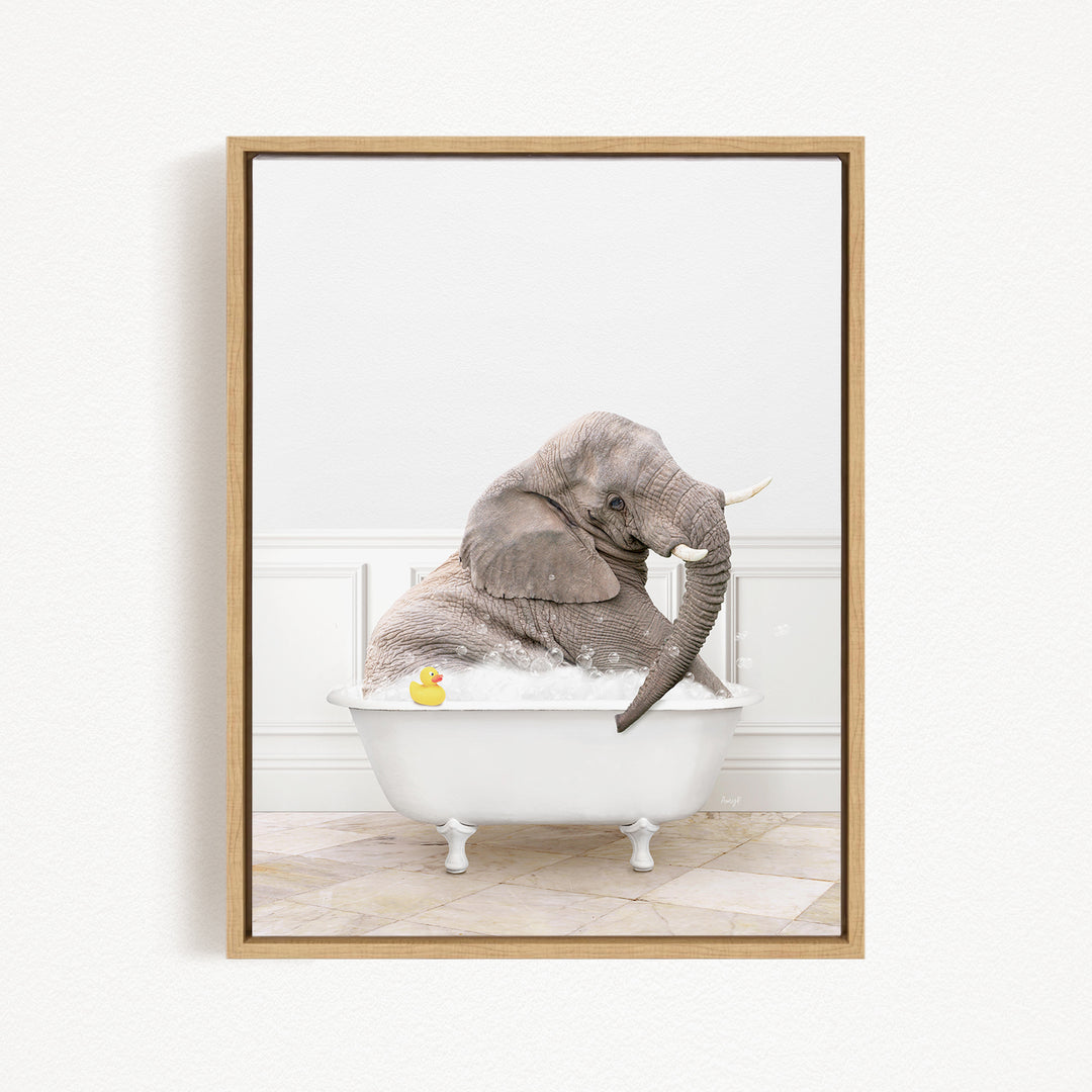 A gray elephant is sitting in a white bathtub, with a yellow rubber duck floating on the water.