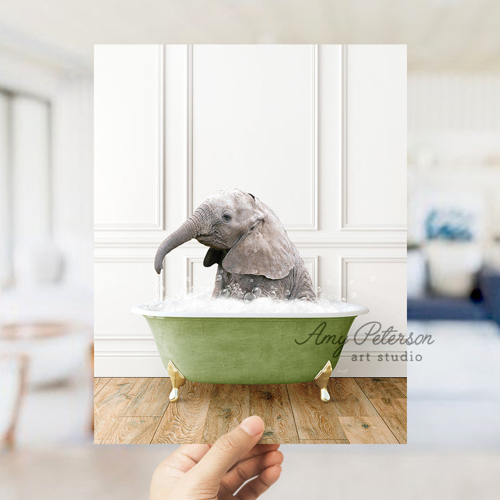 a hand holding a photo of an elephant in a bathtub