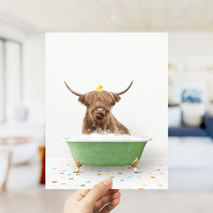 A brown cow with horns is sitting in a green bathtub filled with bubbles, with a yellow rubber duck perched on its head.