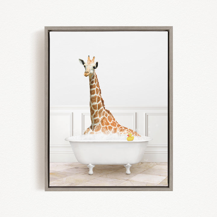 A giraffe sitting in a white bathtub filled with bubbles, with a yellow rubber duck floating in the water.