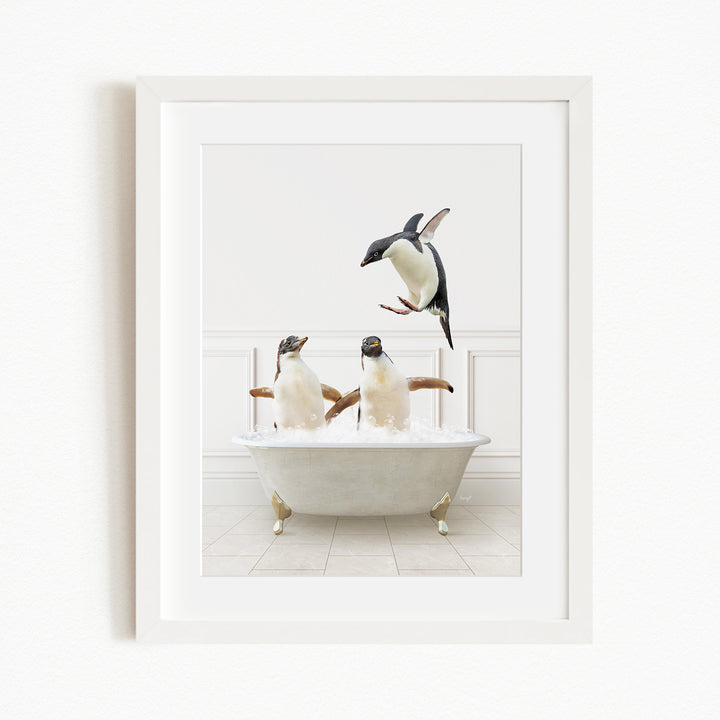 A framed image depicting two penguins sitting in a bathtub, with one penguin flying towards the other penguin.