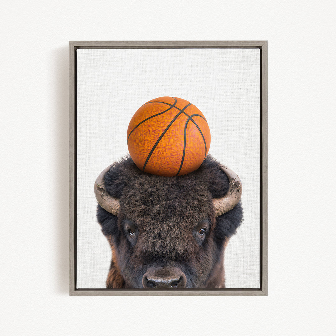A buffalo with a basketball resting on its head.