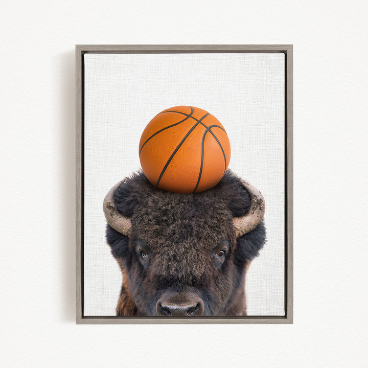 A buffalo with a basketball resting on its head.