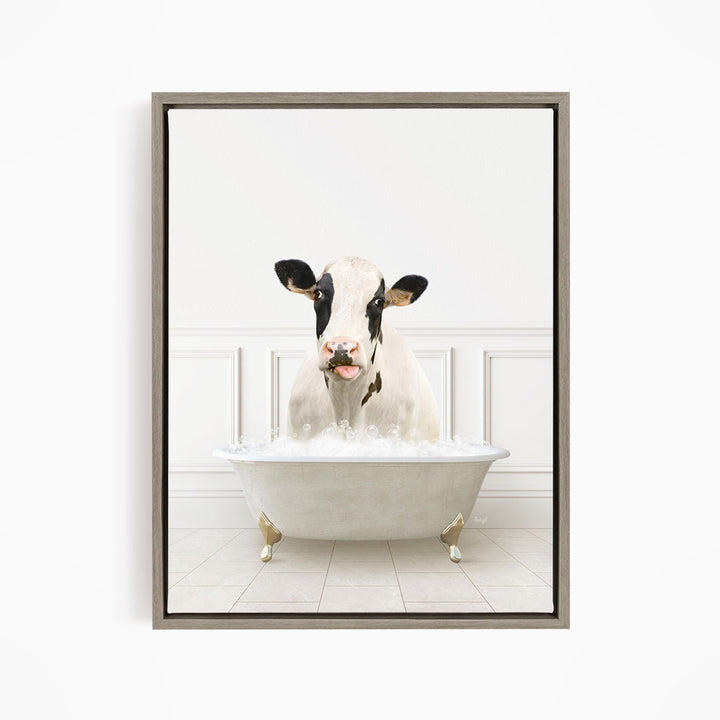 A black and white cow is sitting in a white bathtub filled with water, creating a whimsical and humorous scene.