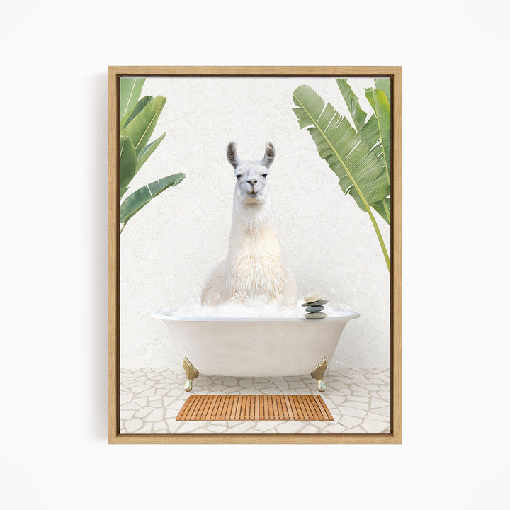 A white llama sitting in a white bathtub filled with bubbles, surrounded by green leaves and a wooden mat on the floor.