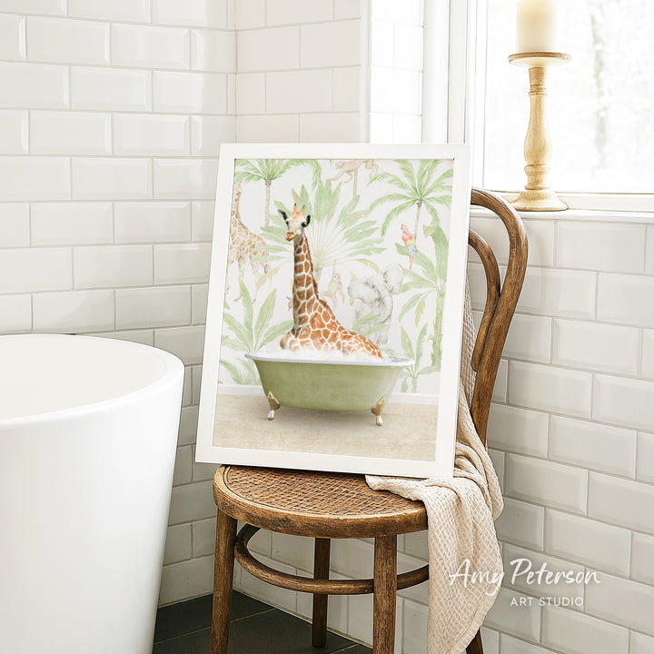 A framed painting of a giraffe sitting in a bathtub is displayed on a wooden chair in a bathroom setting.