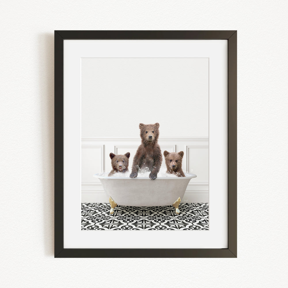 A framed image depicting three bears sitting in a bathtub filled with water, with a patterned rug on the floor beneath them.