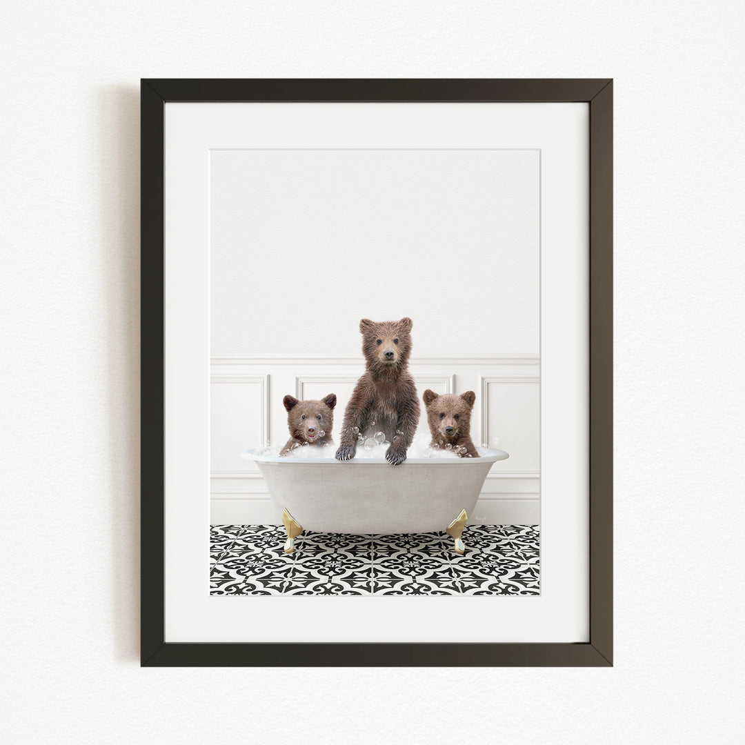 A framed image depicting three bears sitting in a bathtub filled with water, with a patterned rug on the floor beneath them.