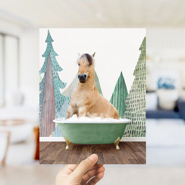 A light brown horse is sitting in a green bathtub, surrounded by a winter landscape with trees and a snowy background.
