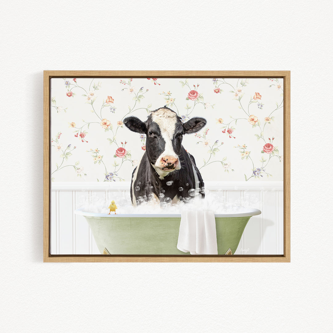 A black and white cow is sitting in a green bathtub filled with bubbles, with a yellow bird perched on the edge of the tub.