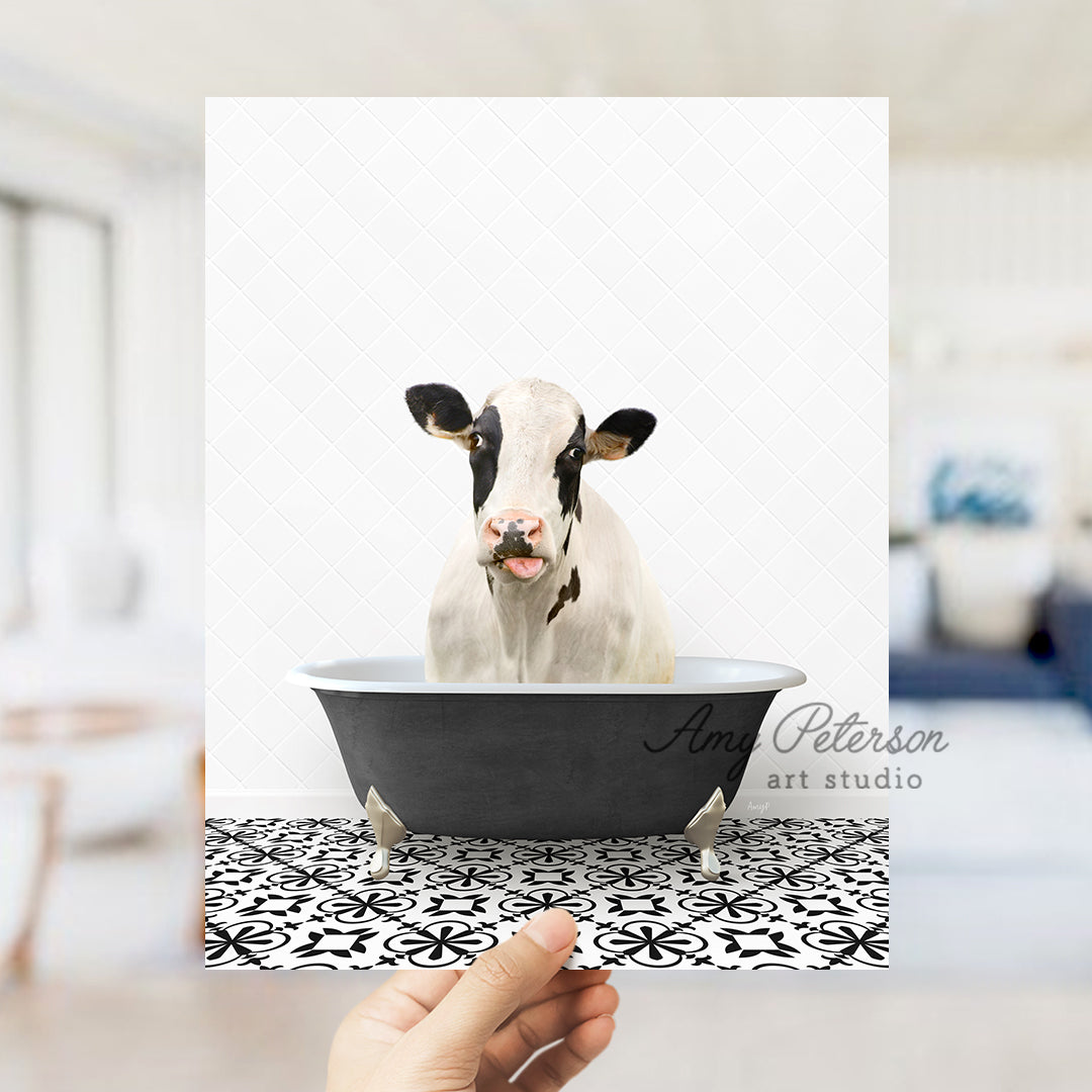 a hand holding a photo of a cow in a bathtub