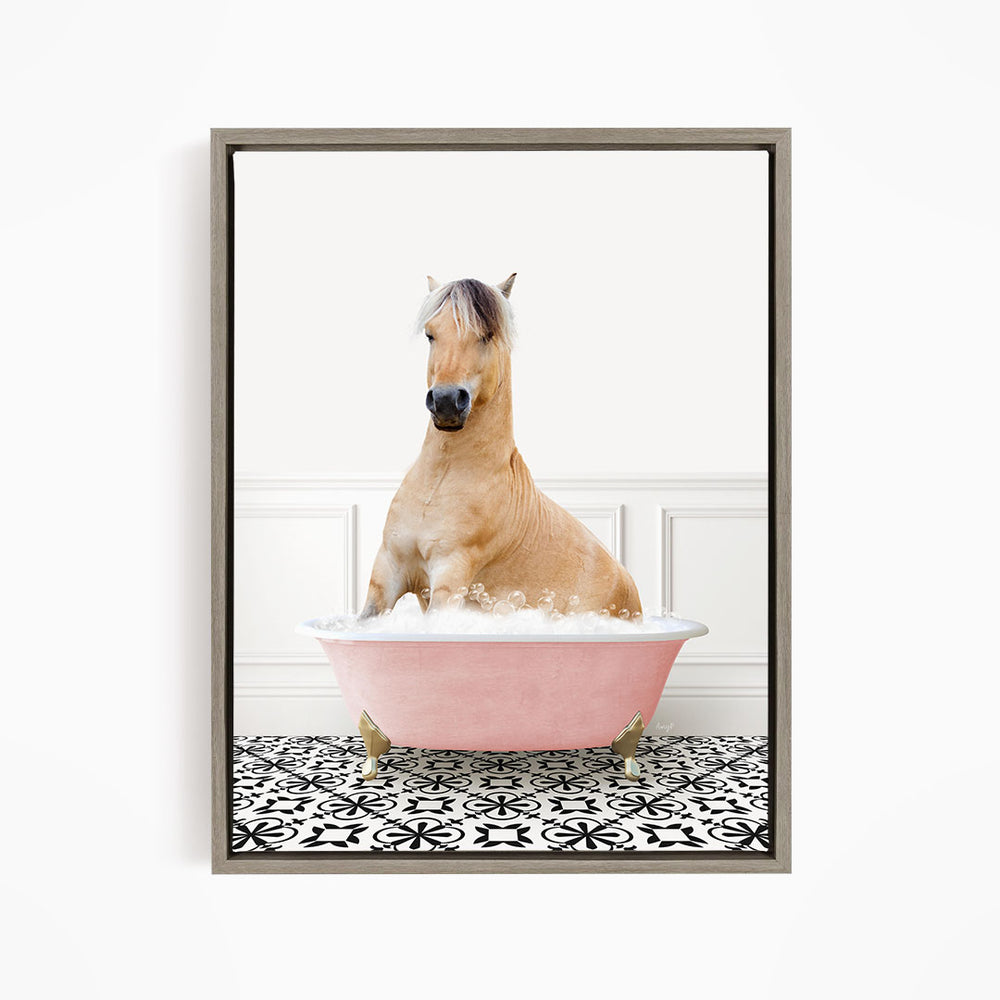 A light brown horse is sitting in a pink bathtub filled with water, surrounded by a black and white patterned floor.