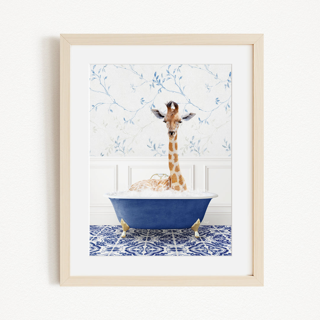 A giraffe is sitting in a blue bathtub filled with water, surrounded by a patterned tile floor and a white wall with blue floral wallpaper.