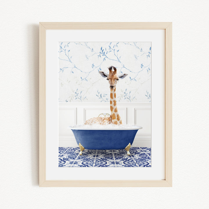 A giraffe is sitting in a blue bathtub filled with water, surrounded by a patterned tile floor and a white wall with blue floral wallpaper.
