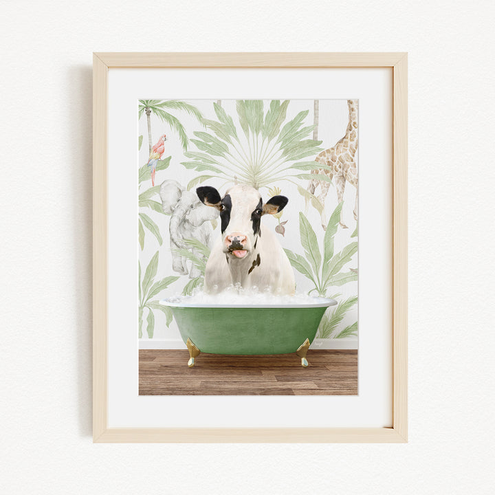 A framed image depicting a cow sitting in a green bathtub, surrounded by tropical foliage and animals.